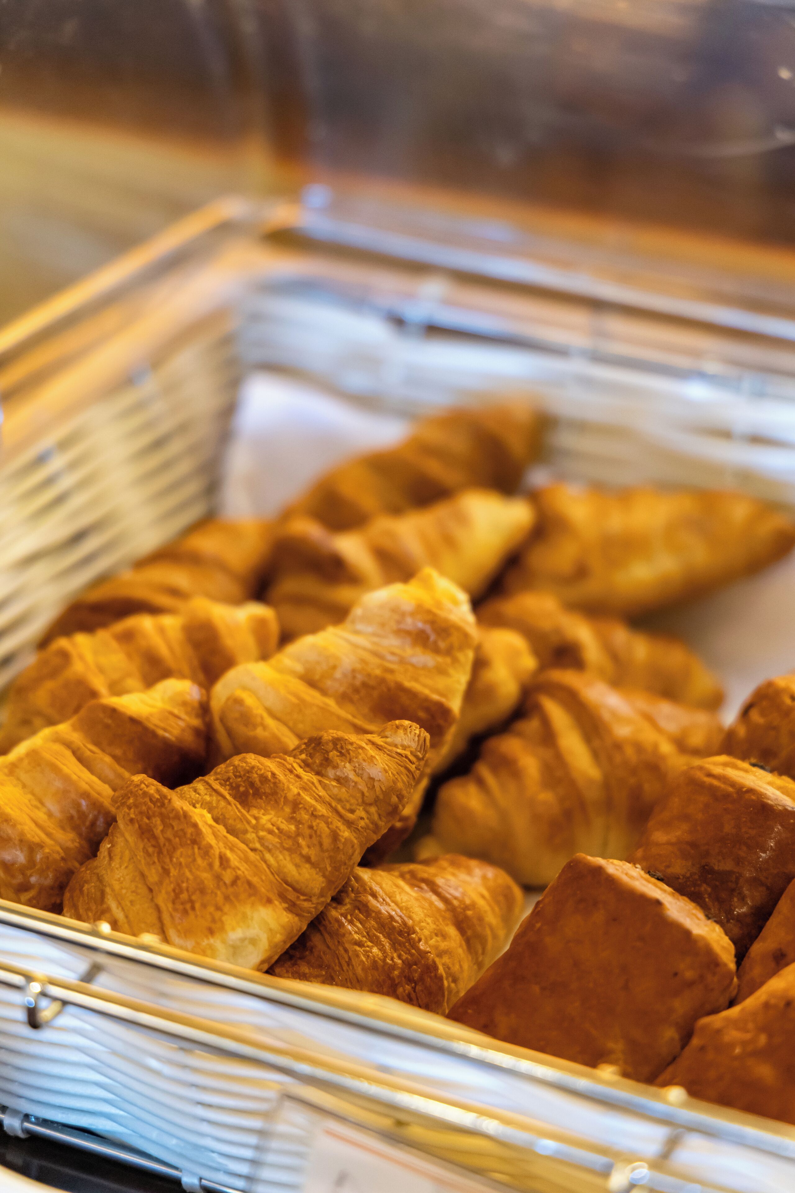 A display case filled with golden-brown croissants.