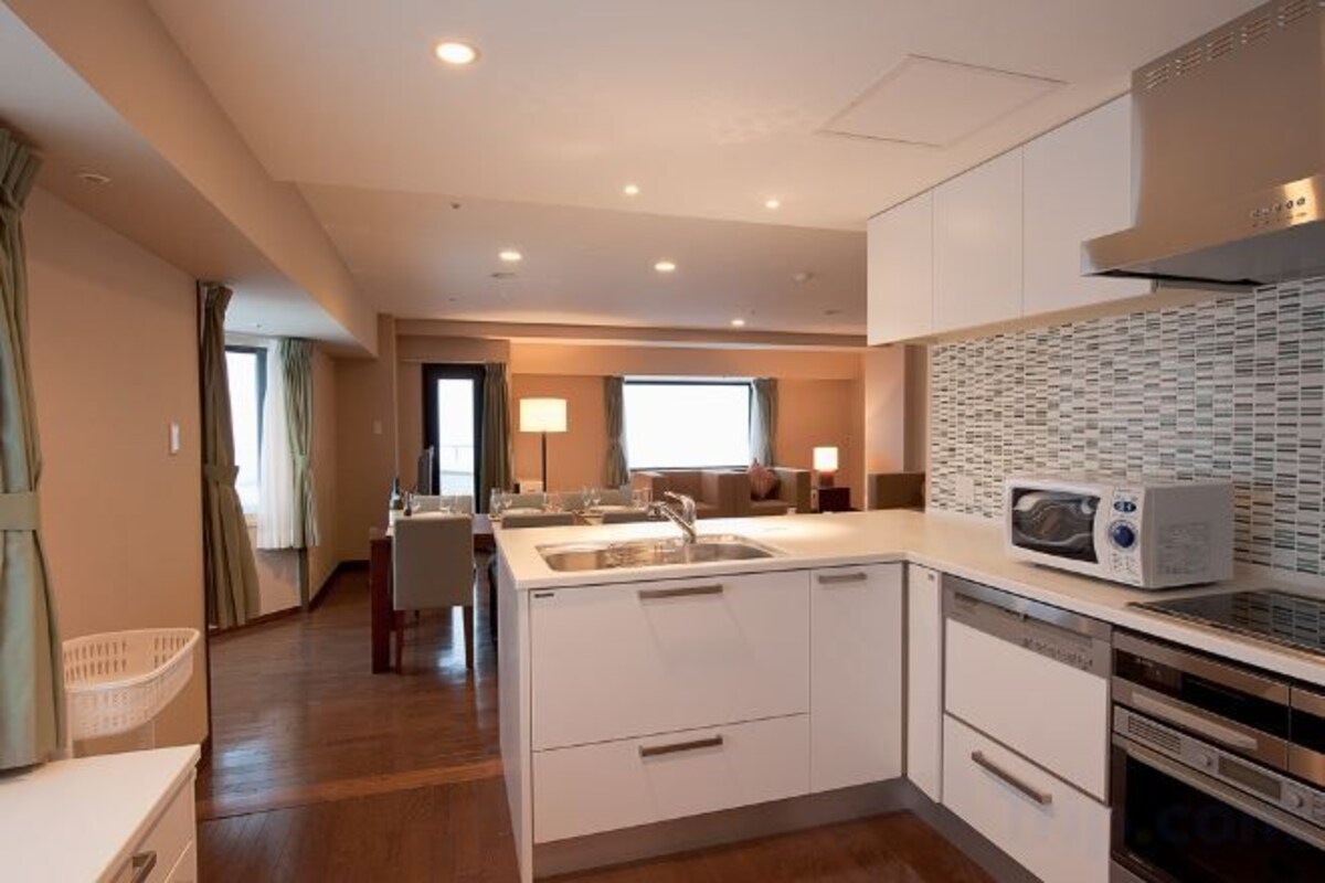 A modern kitchen with white cabinetry, a microwave, and a dishwasher.