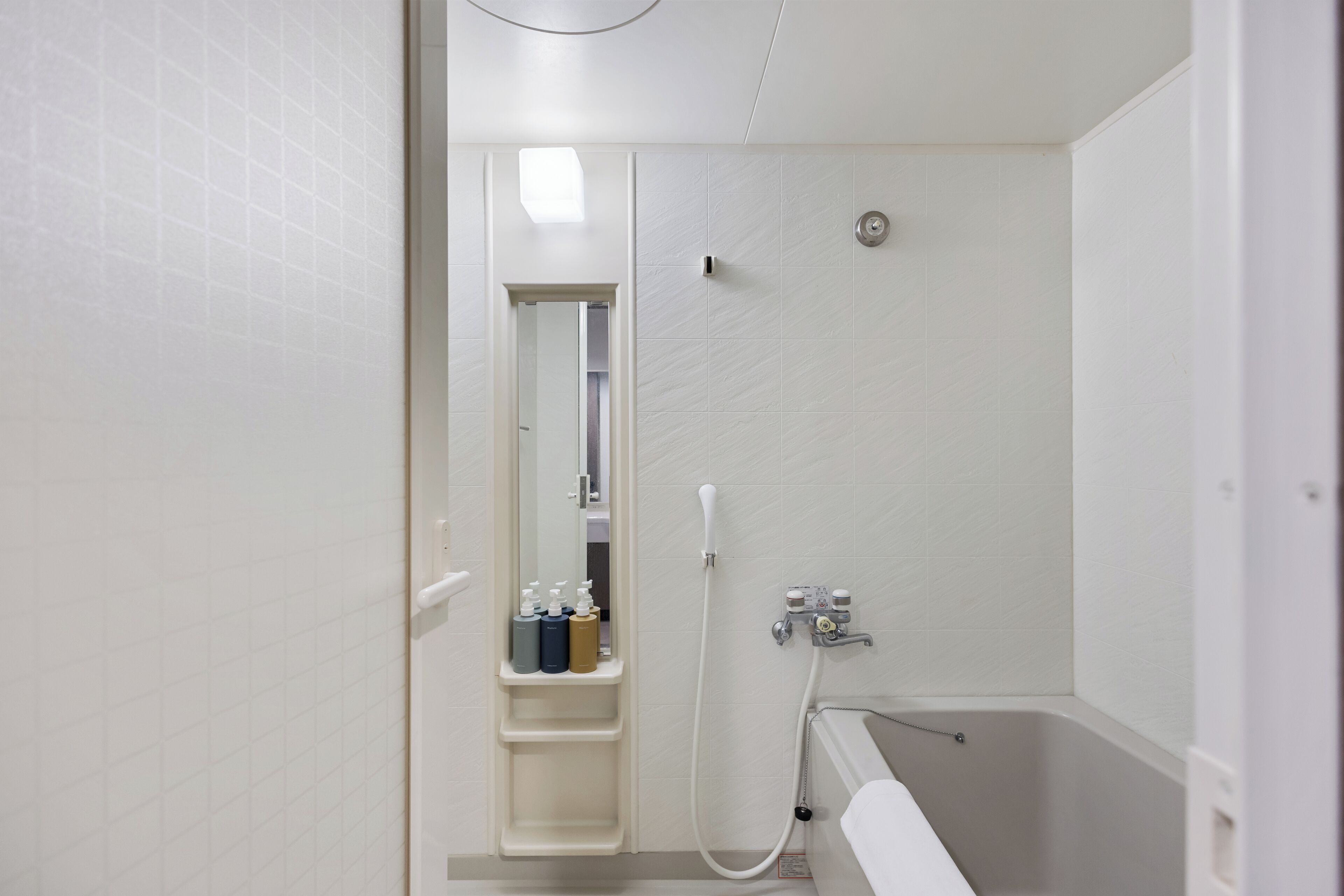 A modern bathroom with a bathtub, a shower, and a vanity with toiletries.