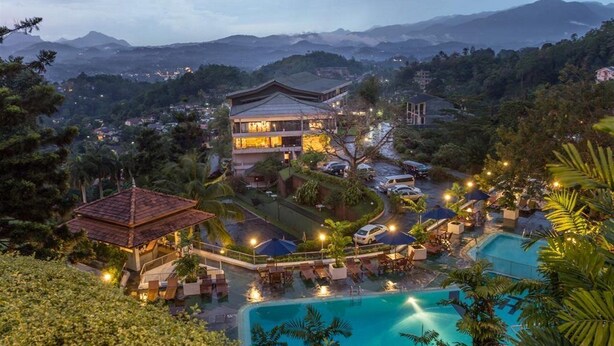 A resort with a large pool, a gazebo, and a traditional building with multiple levels. - The Tourmaline (Kandy)