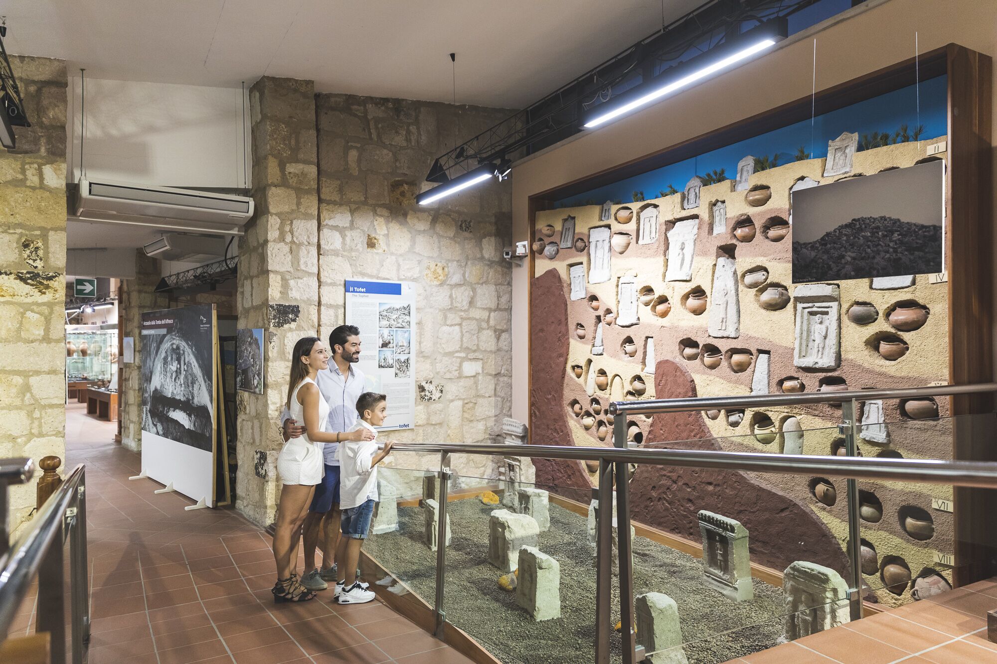 A museum exhibit with stone walls and pottery.