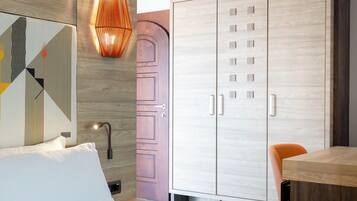 Ein modernes Schlafzimmer mit einem Bett, einem Holzschrank, einem Tisch und einem Stuhl.