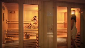 A sauna with wooden benches and a bench with a bucket. - Lu' Hotel Carbonia (Carbonia)