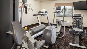 Un gimnasio con equipo de ejercicio, una cinta de correr y una bicicleta estática.