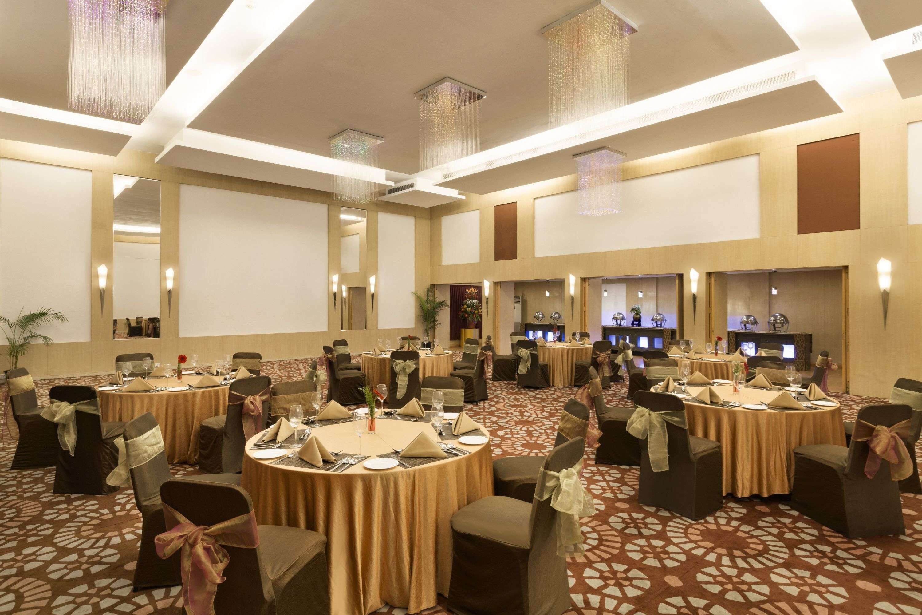 A conference room with round tables, chairs, and a carpeted floor.