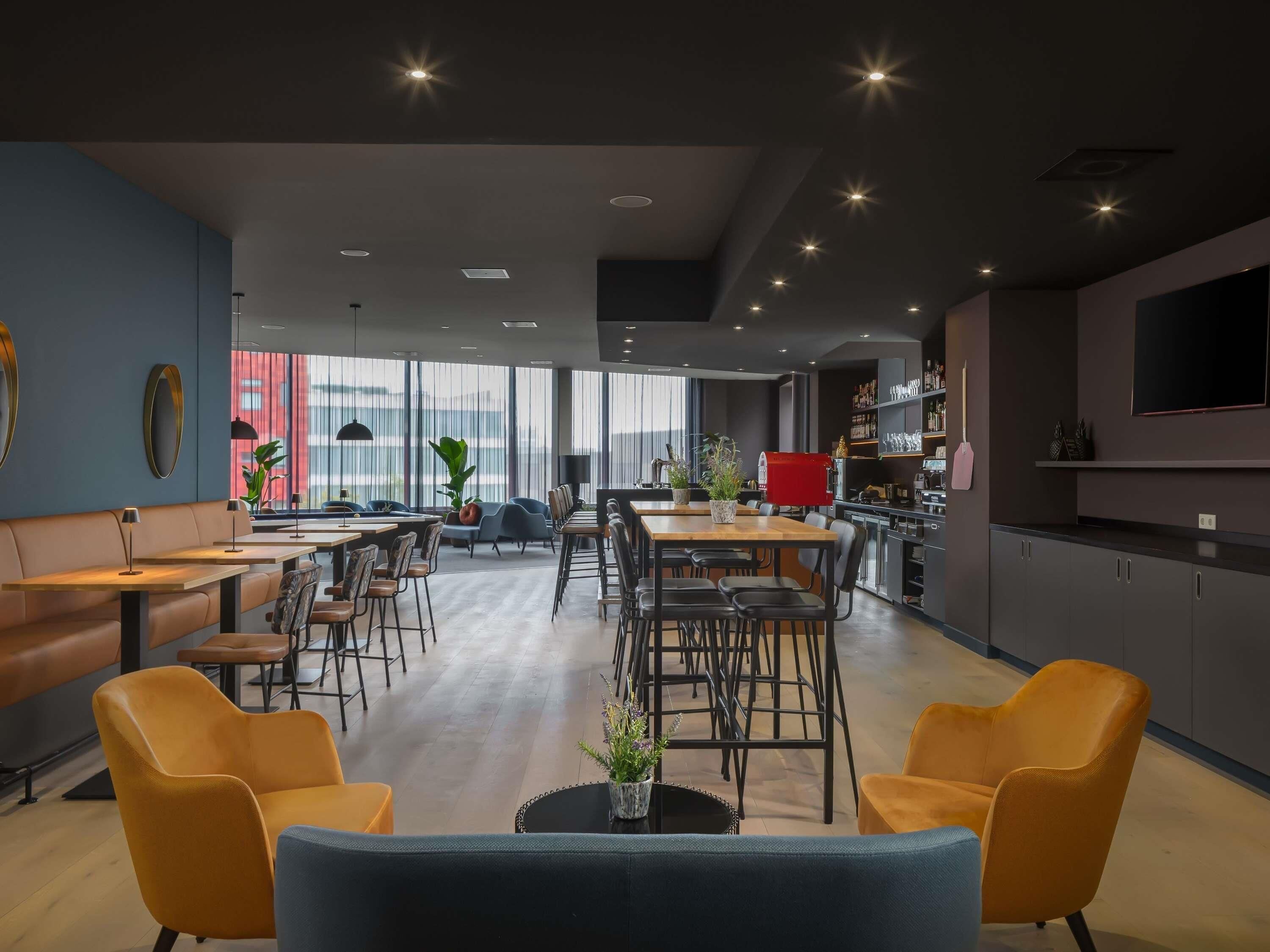 A modern interior with a dining area, seating, and a kitchen.