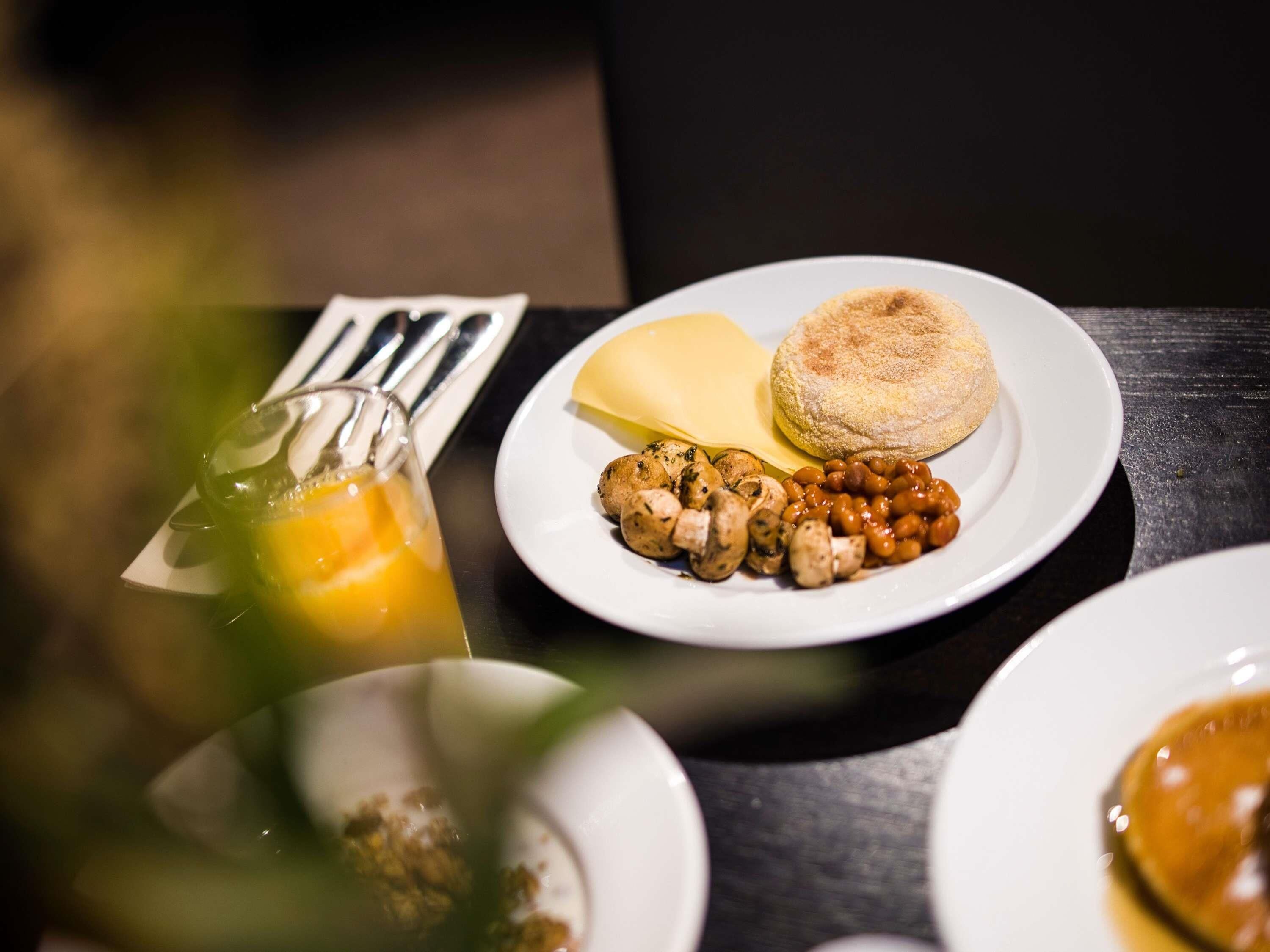 A breakfast setting with a plate of food, a glass of orange juice, and a napkin.
