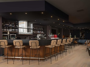 A bar area with multiple stools, a bar counter, shelves with bottles, and a coffee machine. - Mercure City Amersfoort Centre Hotel (Amersfoort)