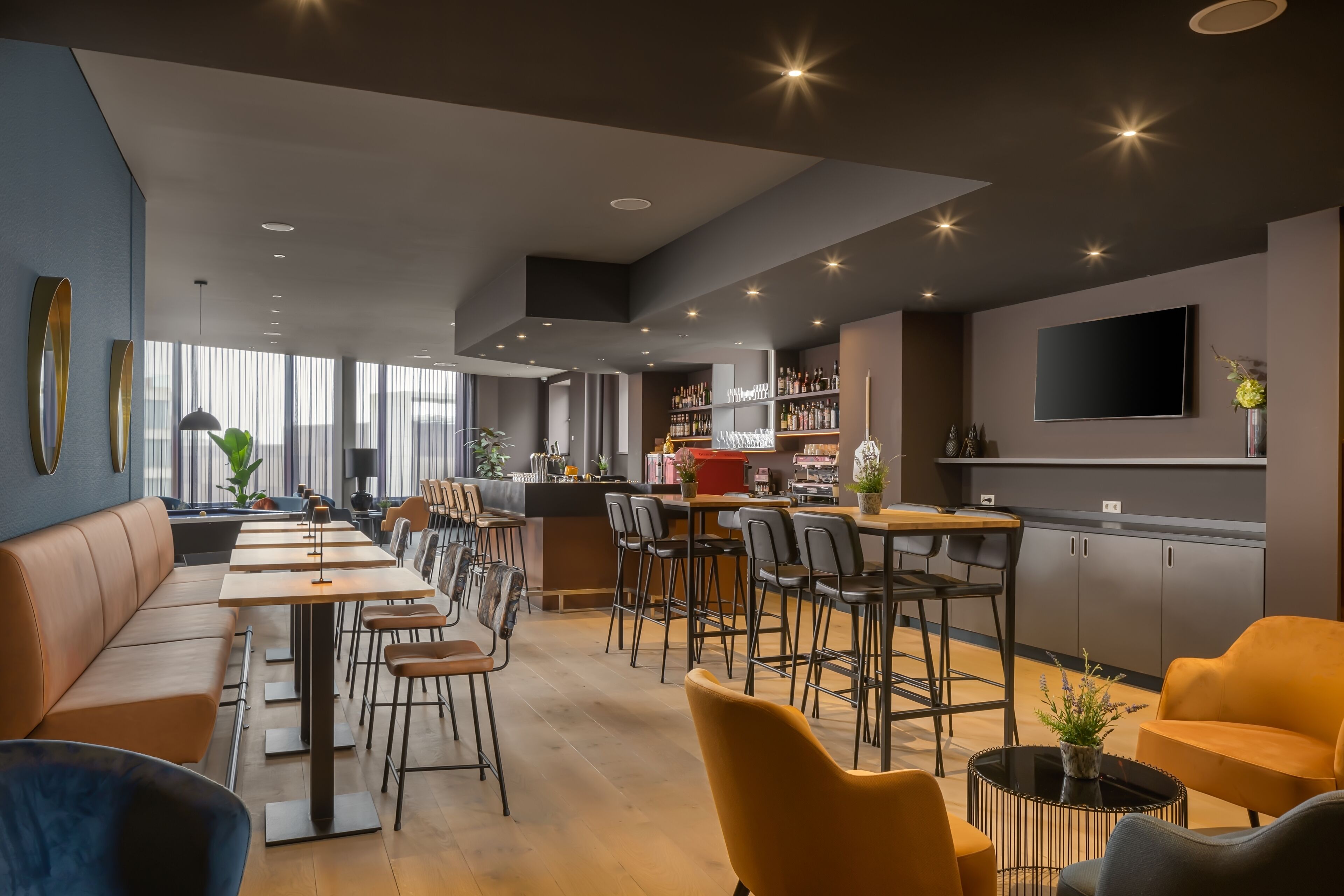 Um restaurante moderno com um balcão extenso, assentos no bar e área de cozinha.