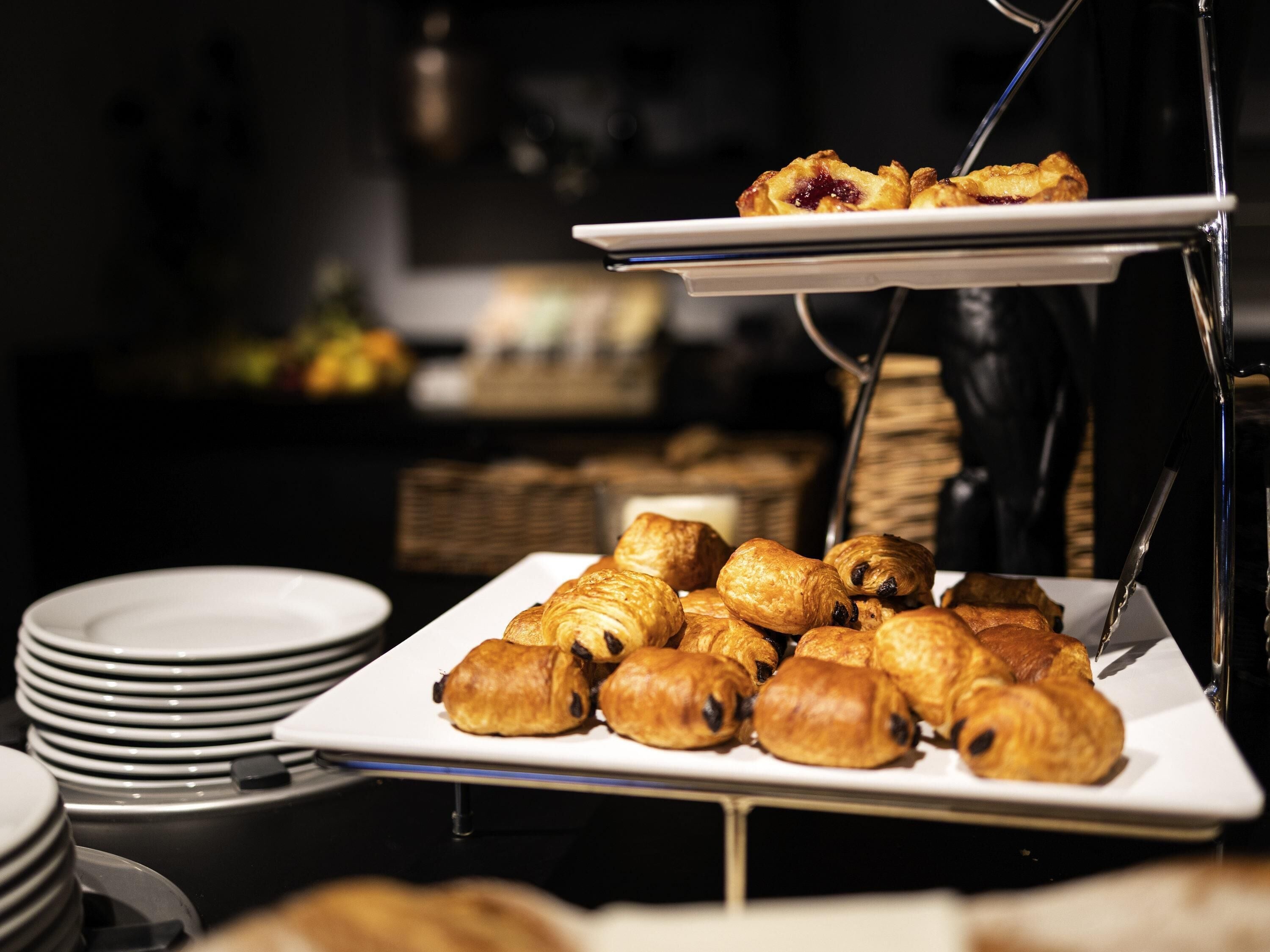 Una mesa de buffet con pasteles y platos.