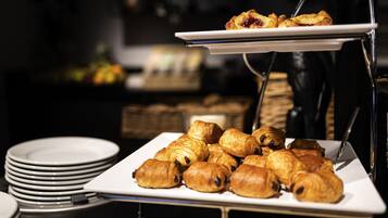 Una mesa de buffet con pasteles y platos.