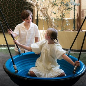 Two children on a swing set outdoors.