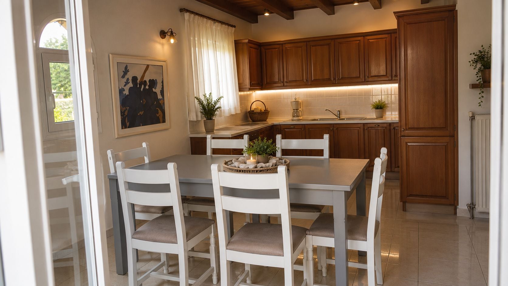 A kitchen with wooden cabinets, a dining table with chairs, and a window with curtains.
