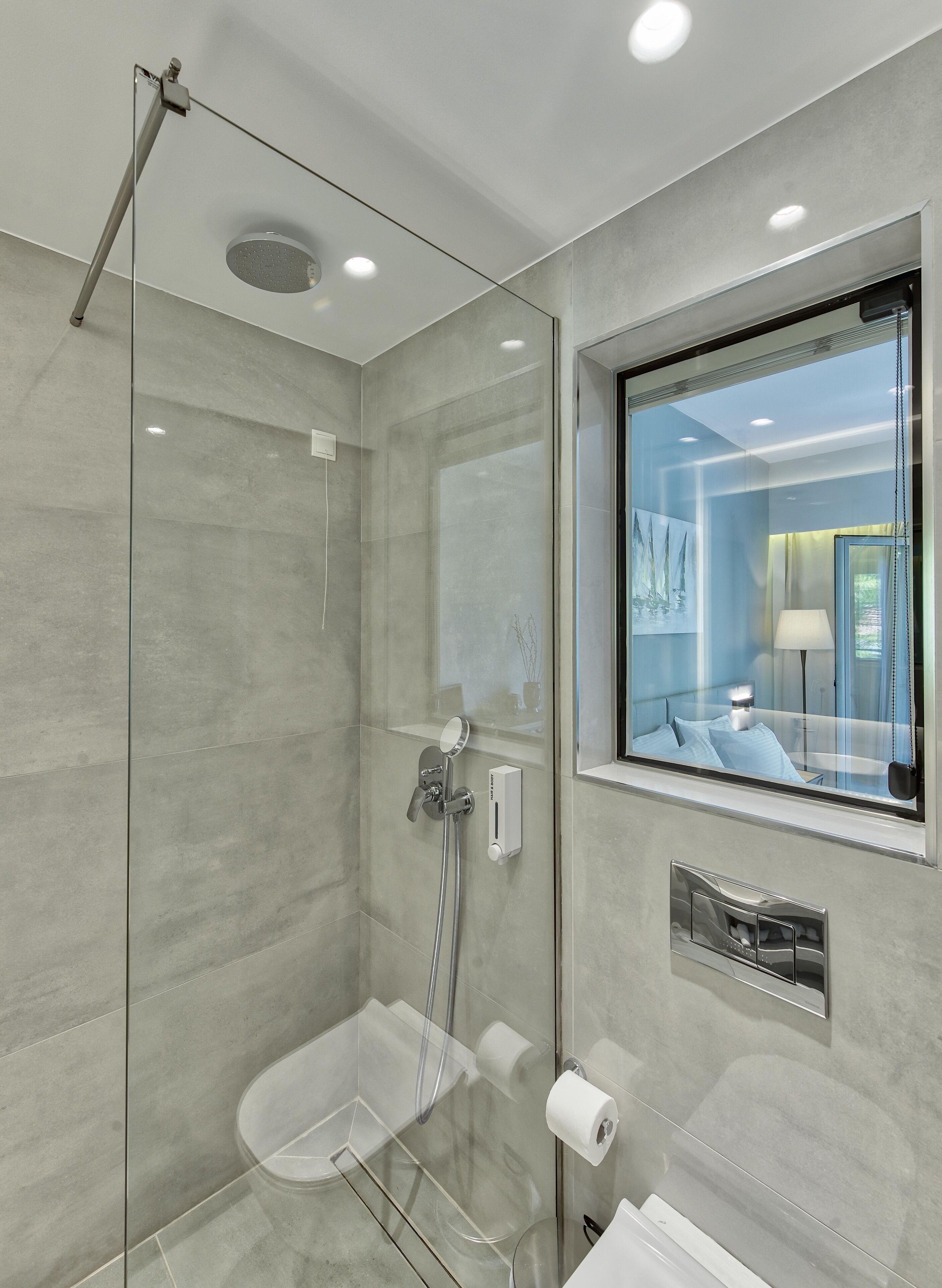 A modern bathroom with a glass-enclosed shower, a toilet, and a bidet.