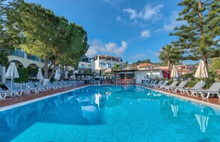 Una piscina al aire libre, sombrillas, sillones reclinables de piscina