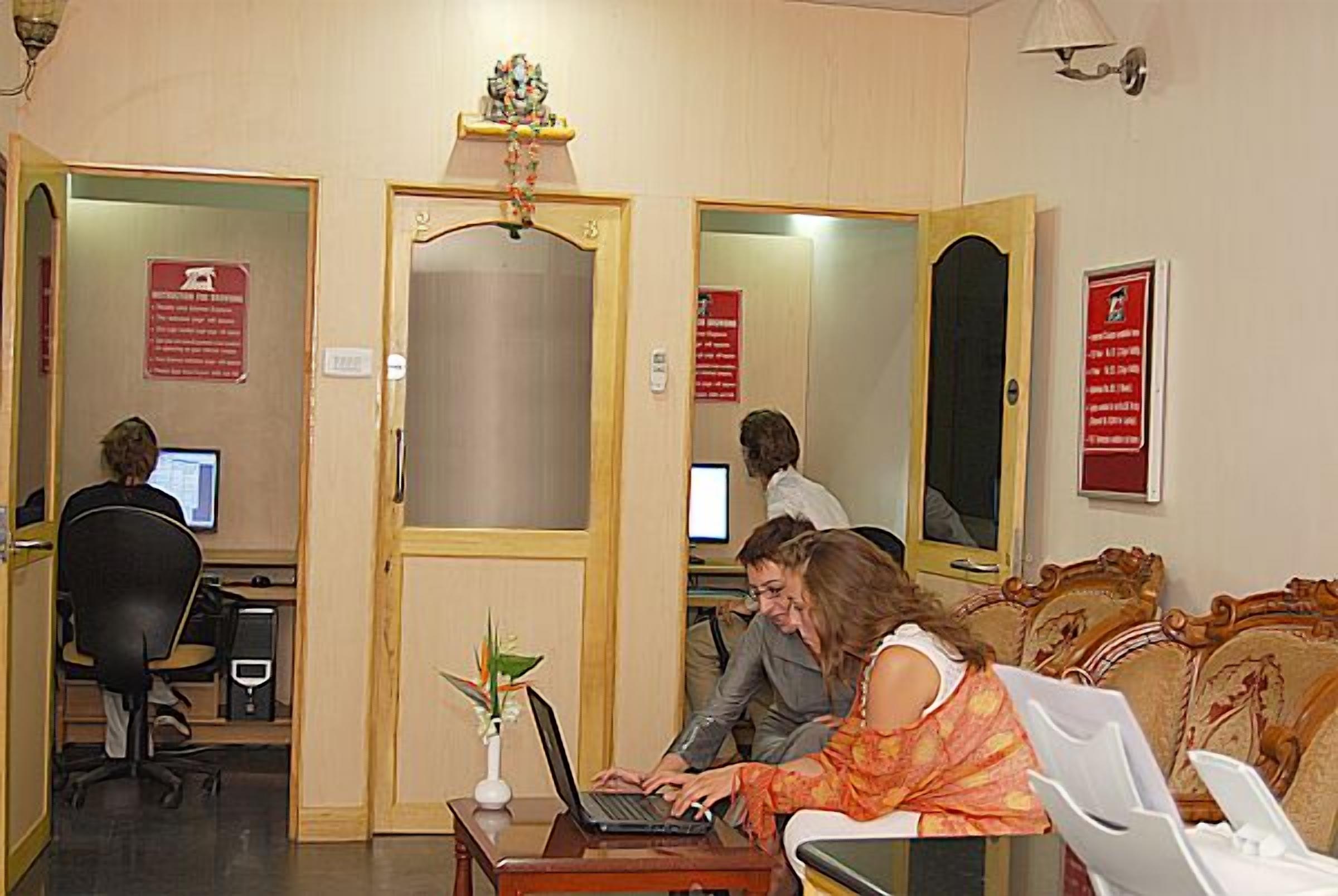 A reception area with a desk, computer, and seating.