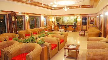 Relax in a traditional lobby with wicker sofas, a wooden coffee table, and elegant artwork.