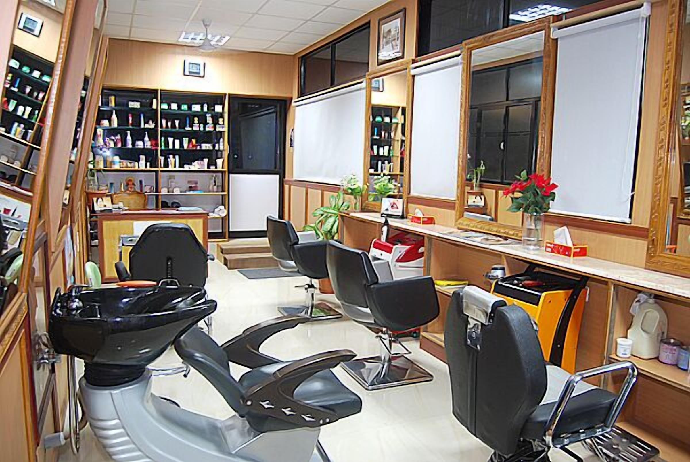 A salon with multiple chairs, a reception desk, and shelves with products.