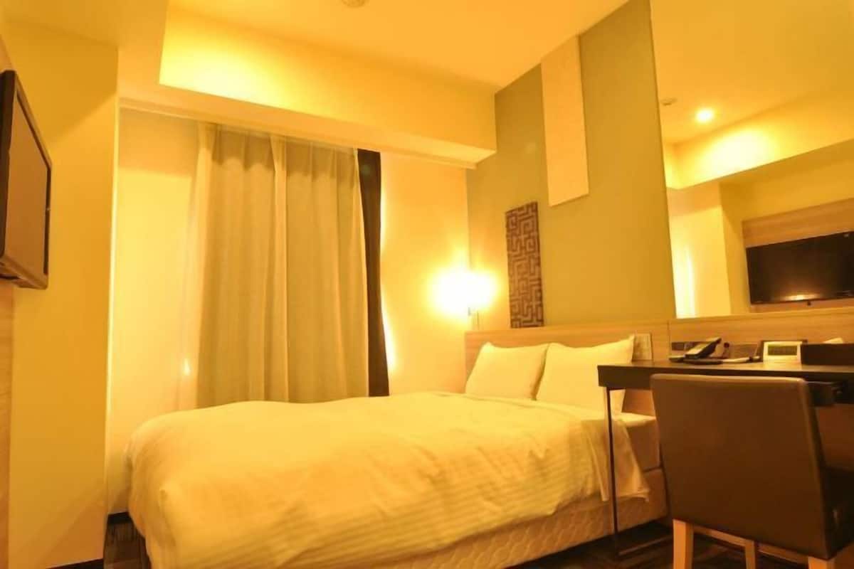 Edredón, espacio para trabajar con laptop y cortinas blackout
