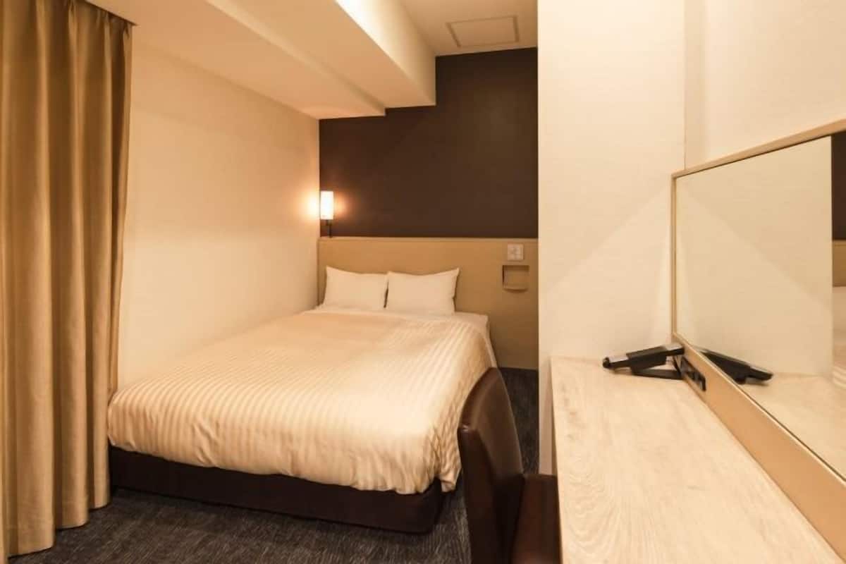 Edredón, espacio para trabajar con laptop y cortinas blackout