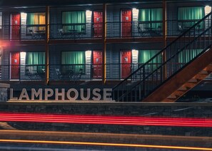 A building with a sign reading "LAMPHOUSE" and a staircase leading to a balcony.
