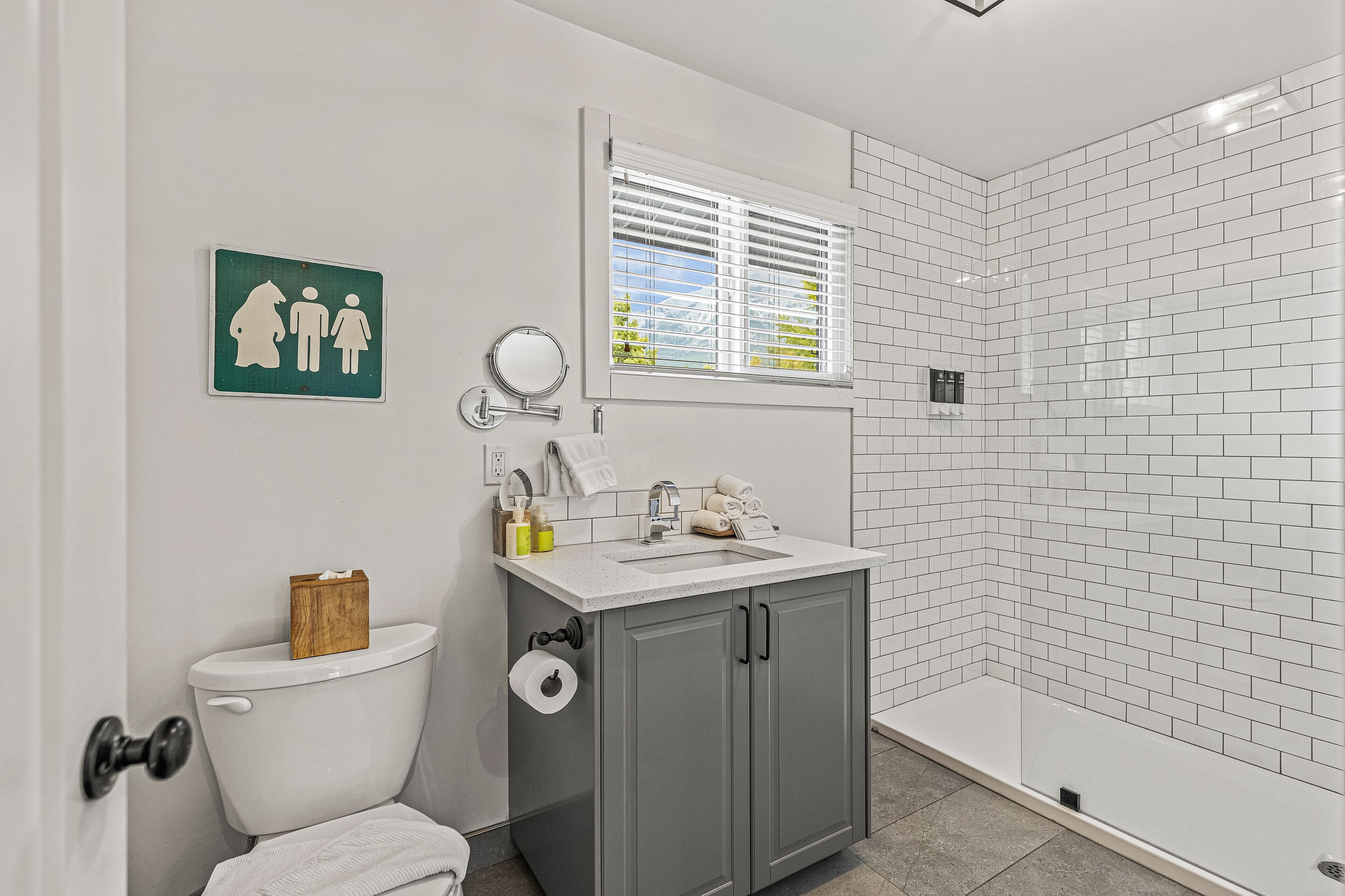 A modern bathroom with a toilet, sink, and shower.