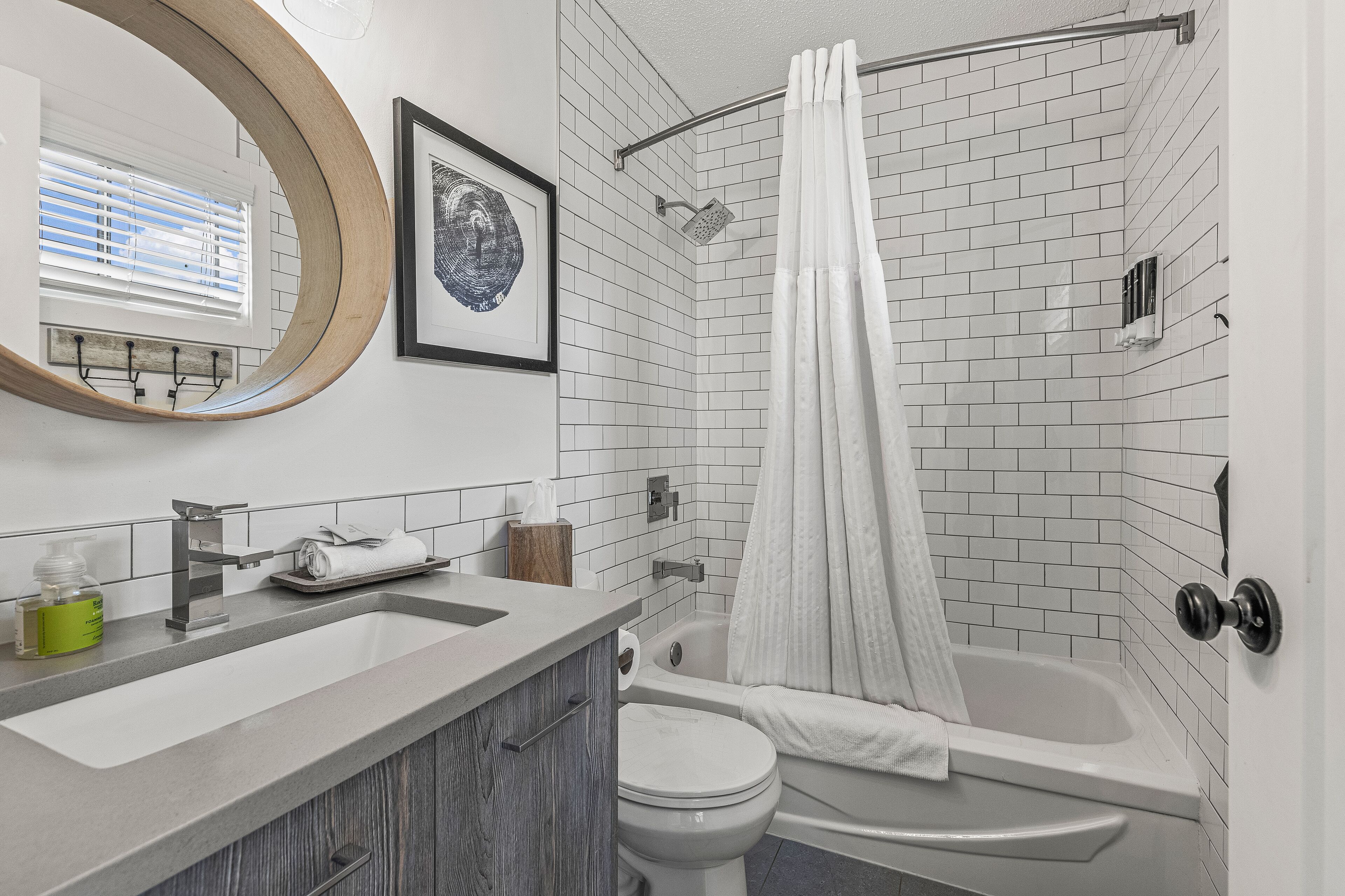 A bathroom with a sink, toilet, and bathtub, all in white.