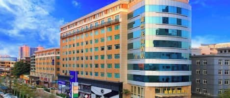 A multi-story hotel with a modern design, featuring a curved facade and large windows.