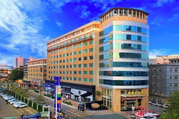 A multi-story hotel with a modern design, featuring a curved facade and large windows.