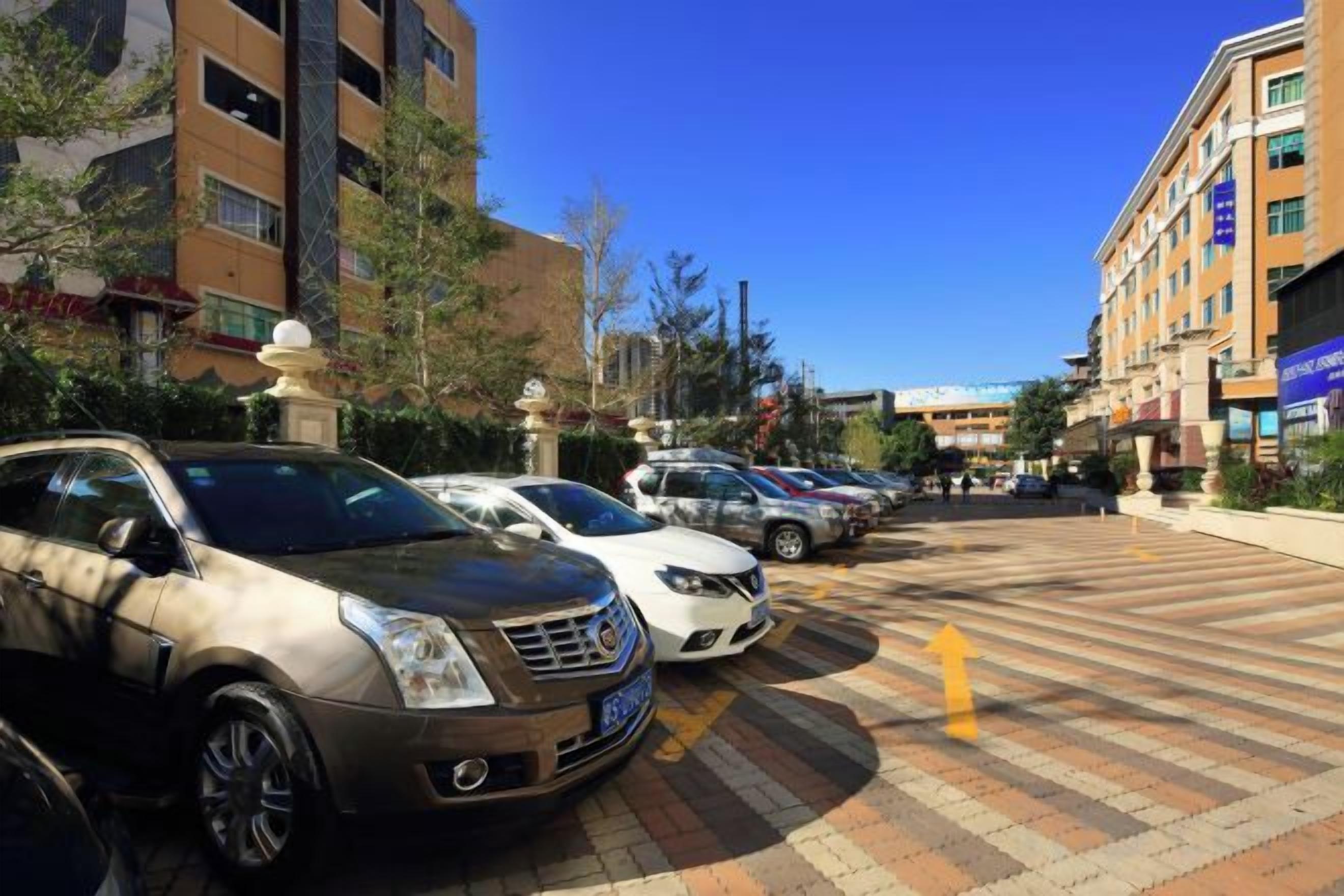 A parking lot with multiple cars and a clear sky.