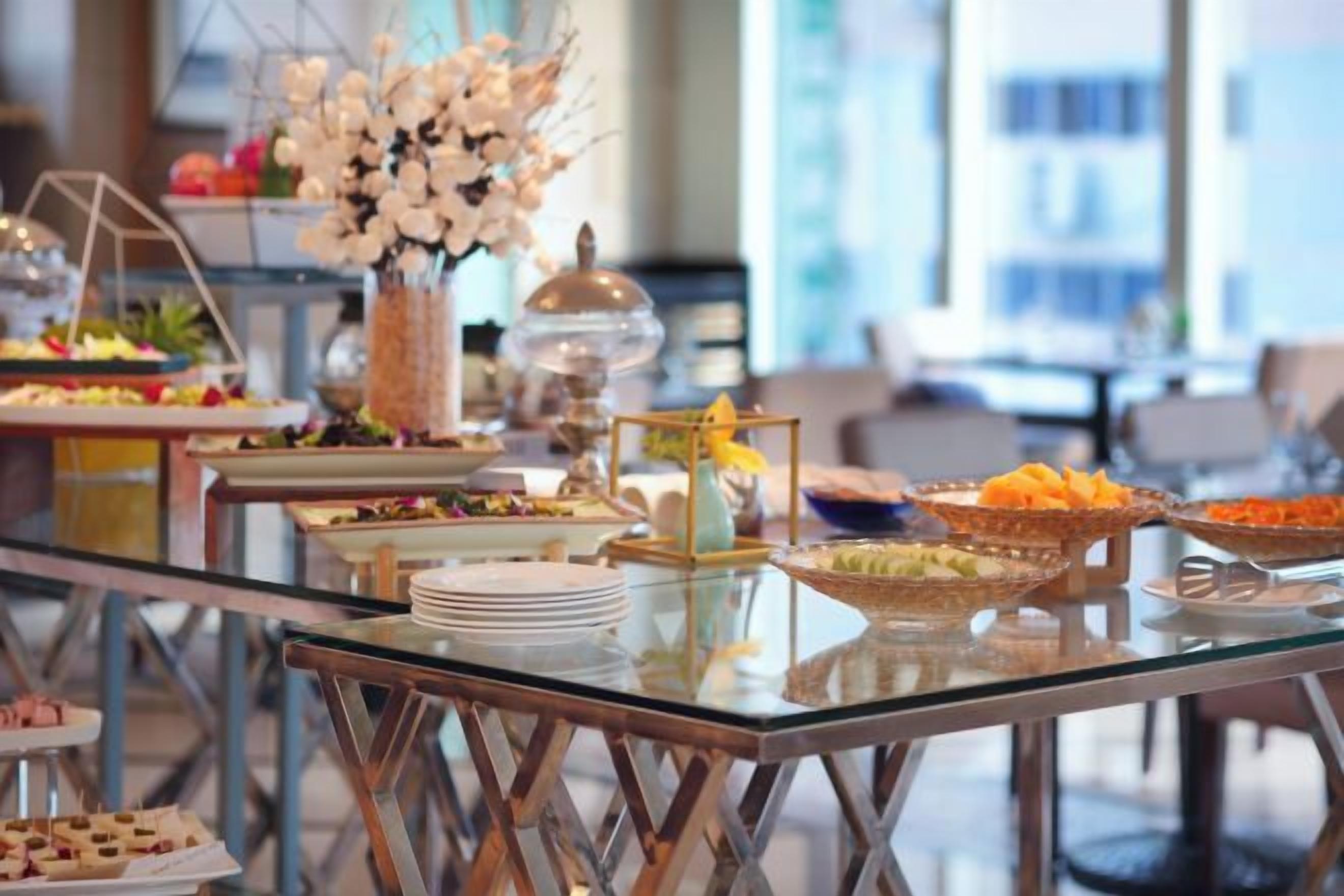 A buffet table with various food items and a decorative centerpiece.