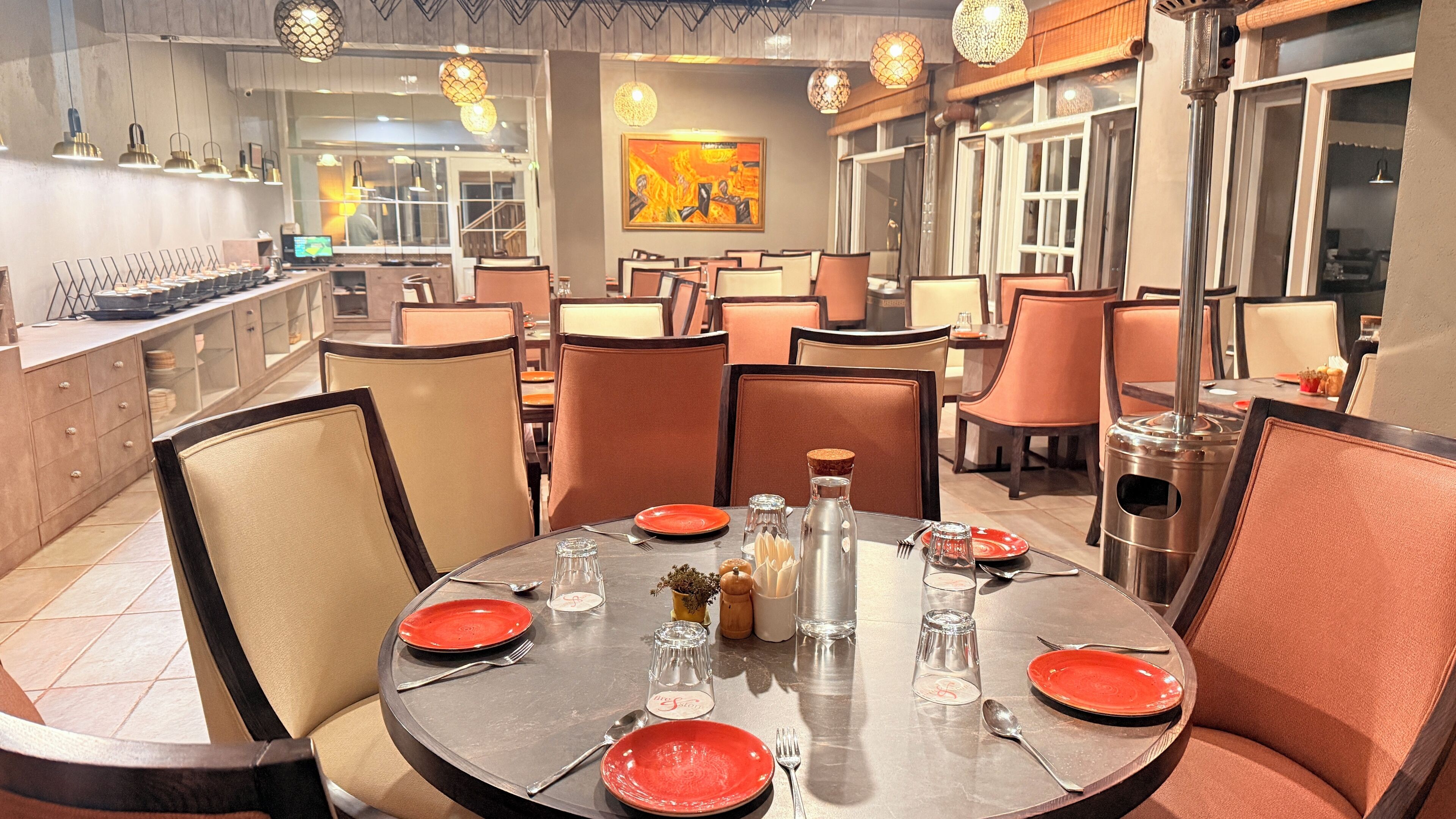 Un restaurant avec des tables rondes, des chaises orange et un décor intérieur moderne.