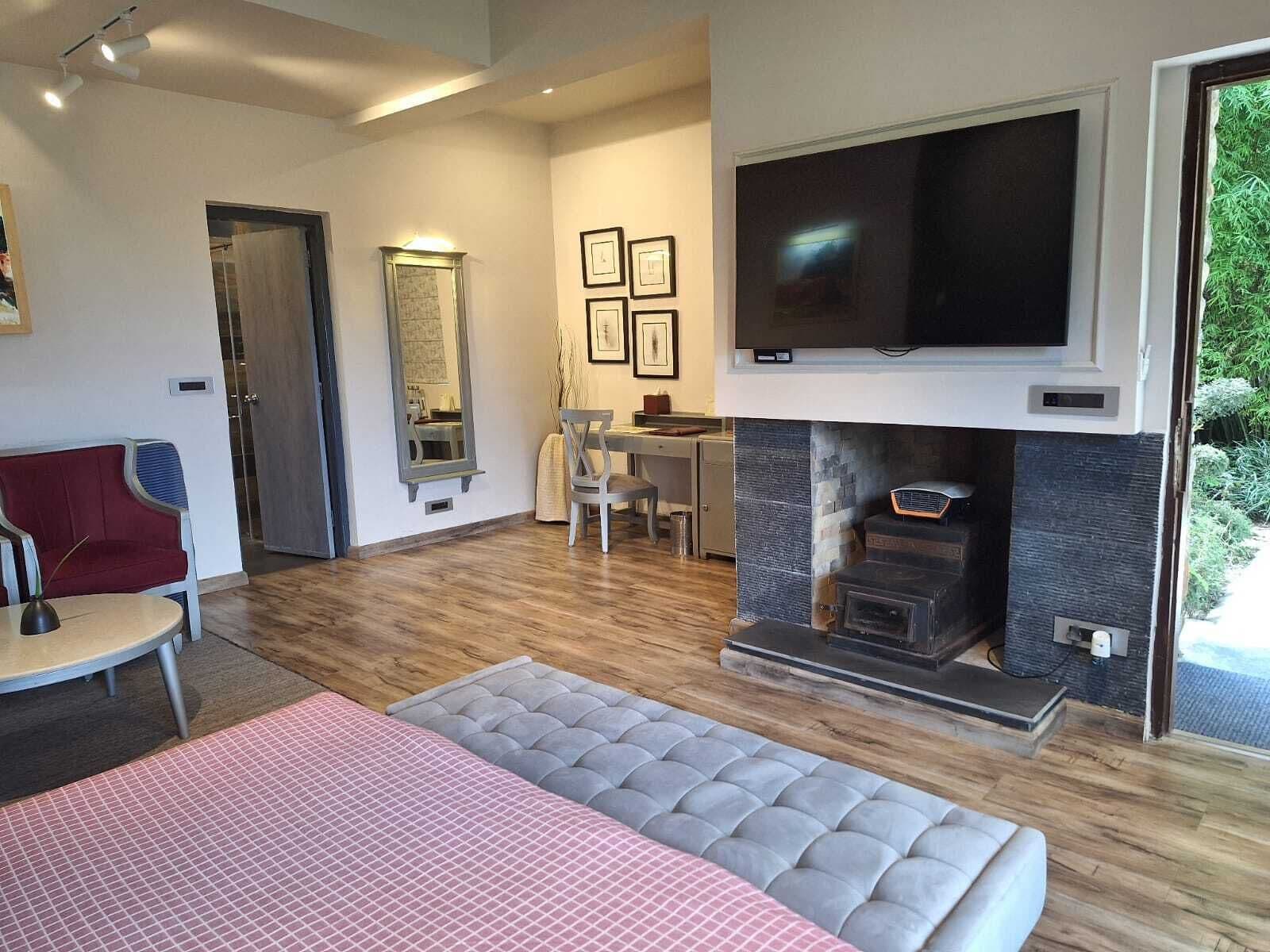 A modern living room with a fireplace, a television mounted above it, and a dining area with a table and chairs.