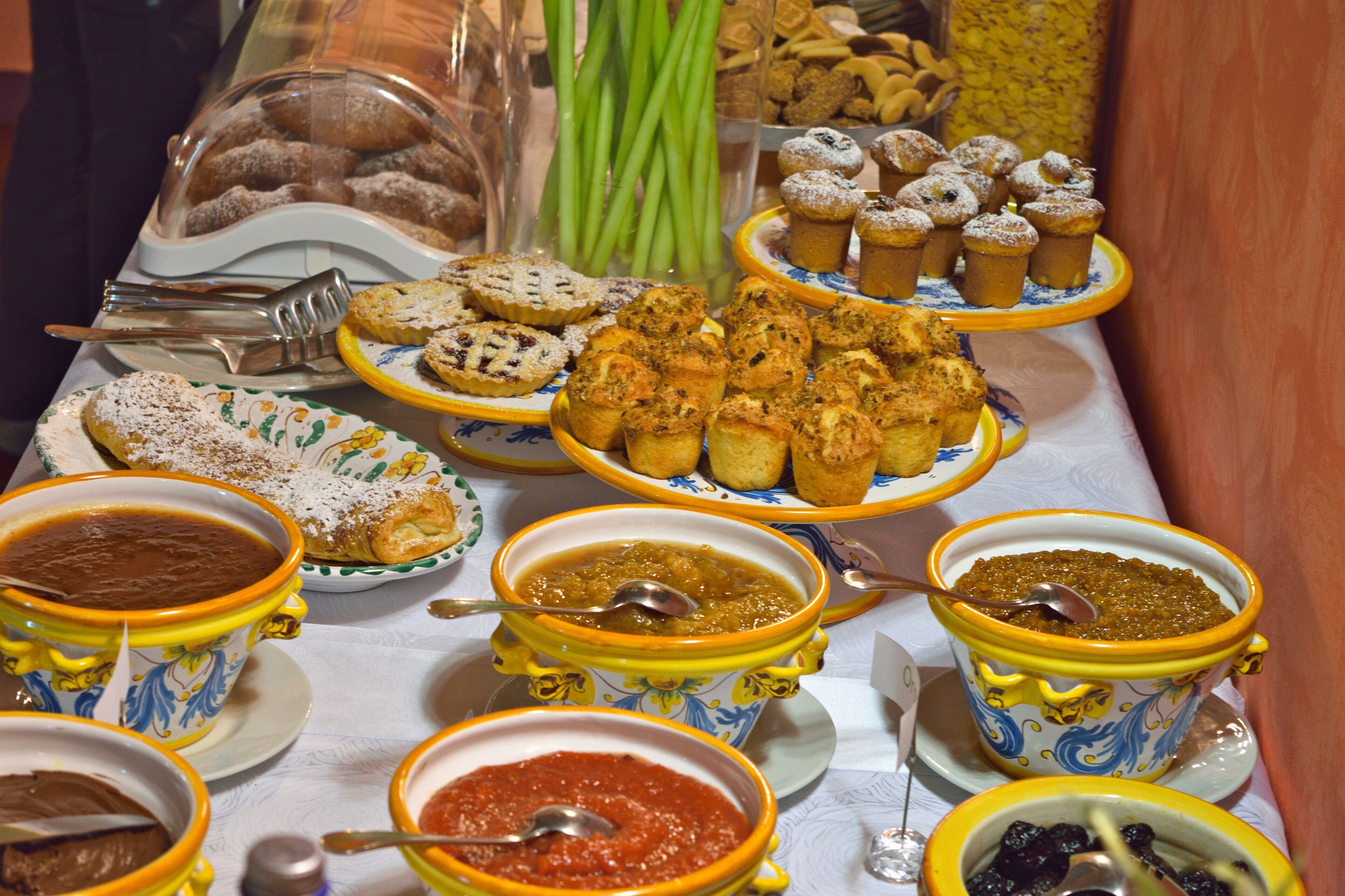 A buffet table with various food items and dishes.