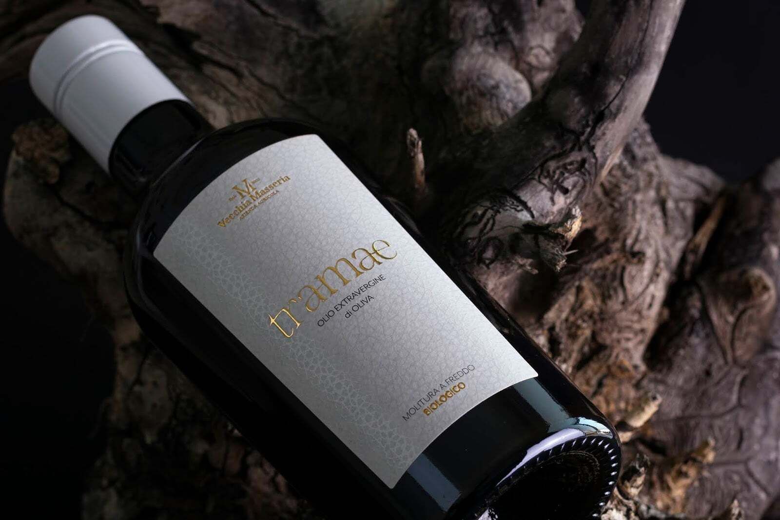 A bottle of wine with a label that reads "Tramae" and "OLIO EXTRA VERVIGNE DI OLIVA".
