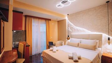 Una habitación de hotel con cama, escritorio, silla y ordenador portátil.