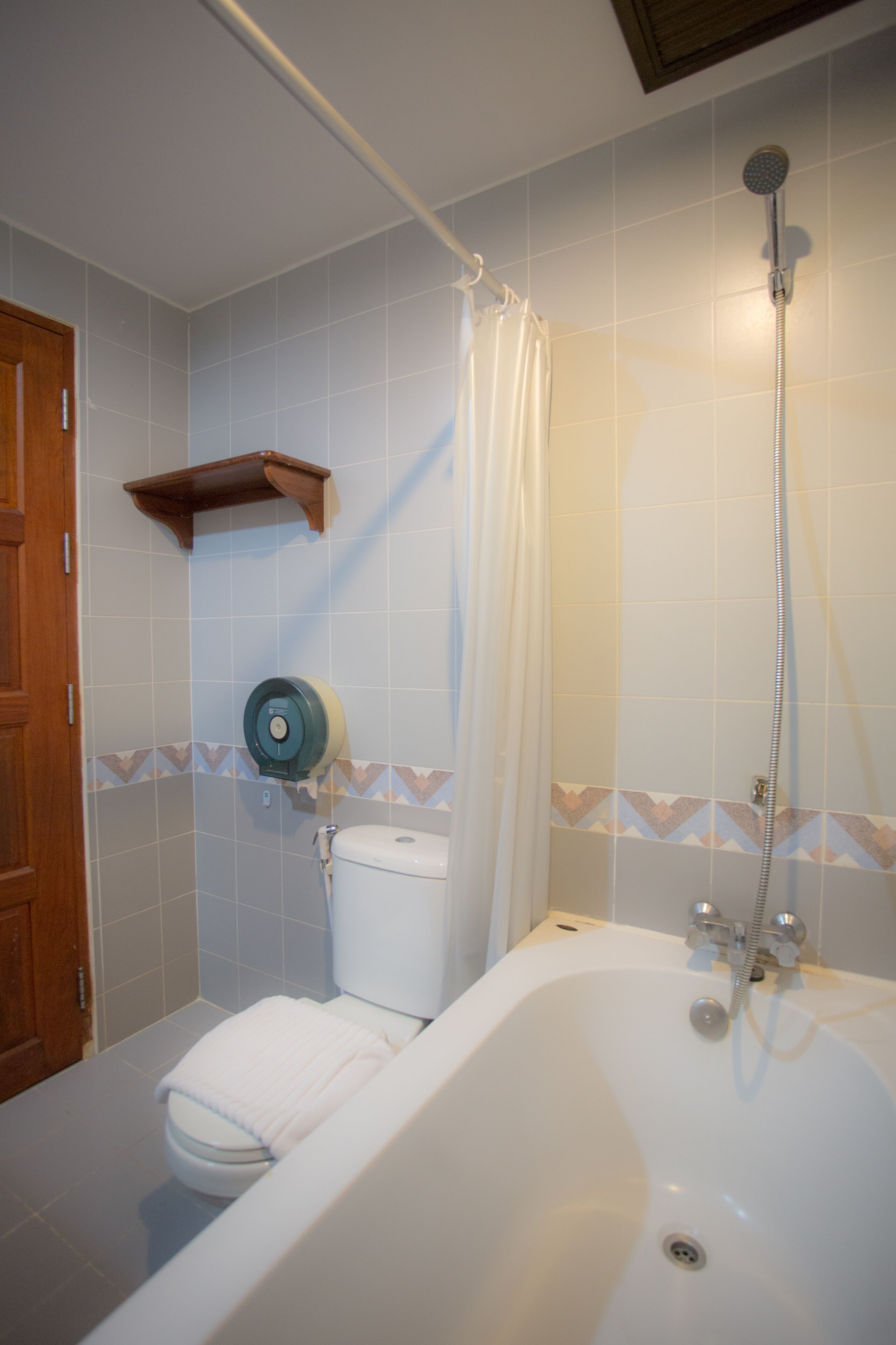 Un baño con bañera, inodoro, ducha y un perchero para toallas.