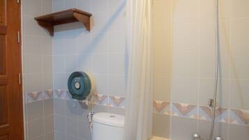 Un baño con bañera, inodoro, ducha y un perchero para toallas.