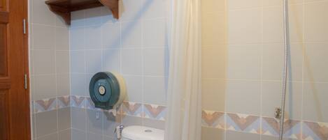 Un baño con bañera, inodoro, ducha y un perchero para toallas.