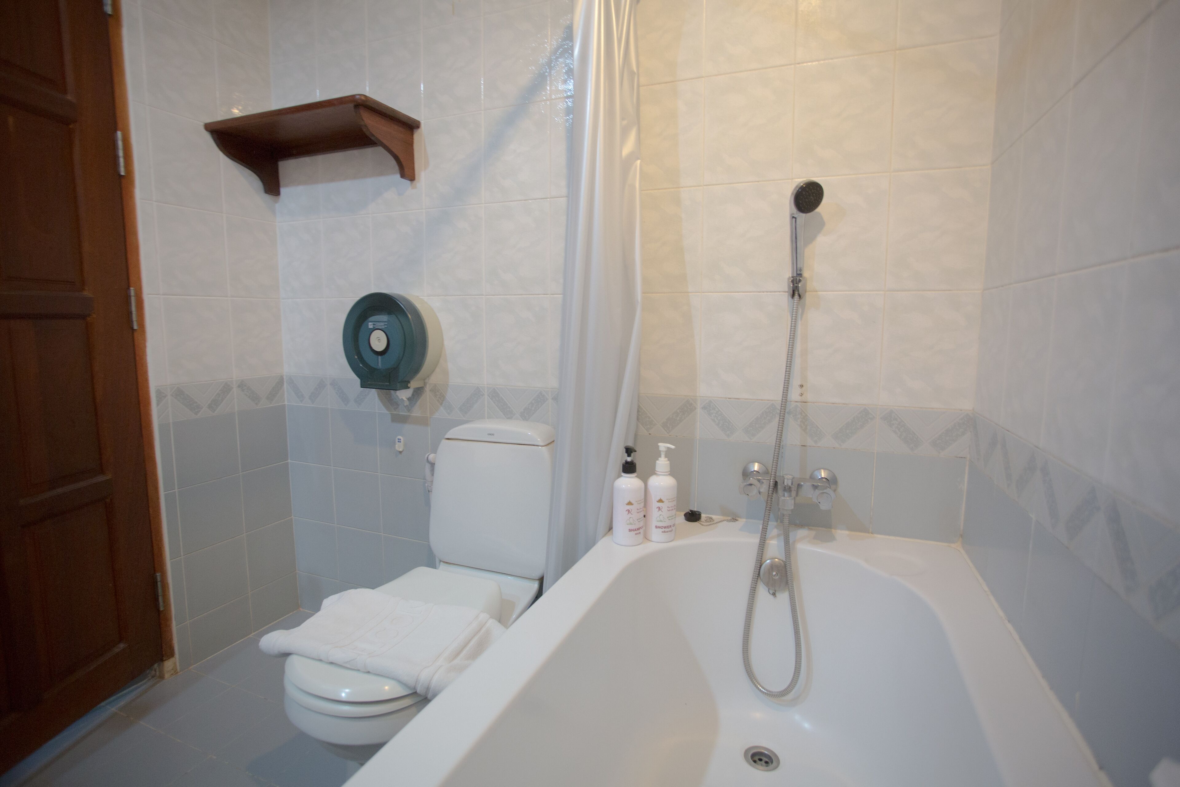 A bathroom with a toilet, a bathtub, and a shower.