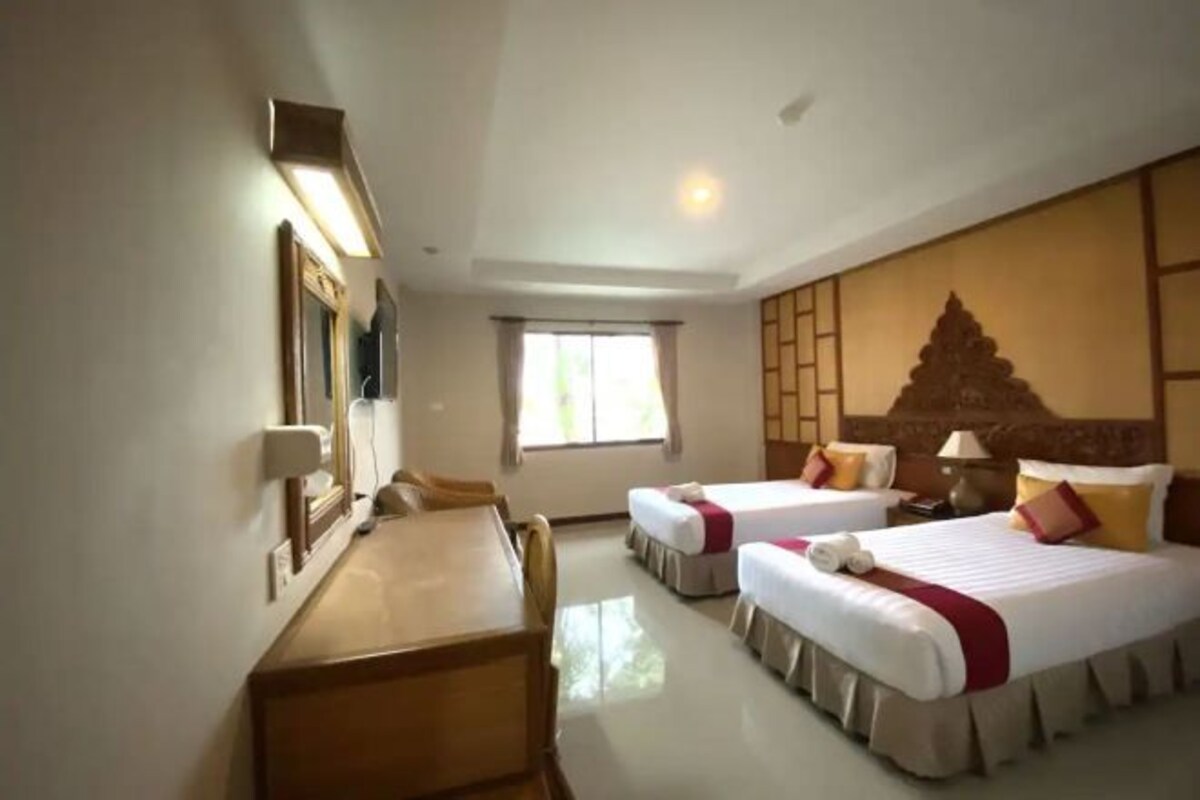 Une chambre d’hôtel avec deux lits, un bureau, une chaise, une fenêtre et un panneau décoratif au mur.