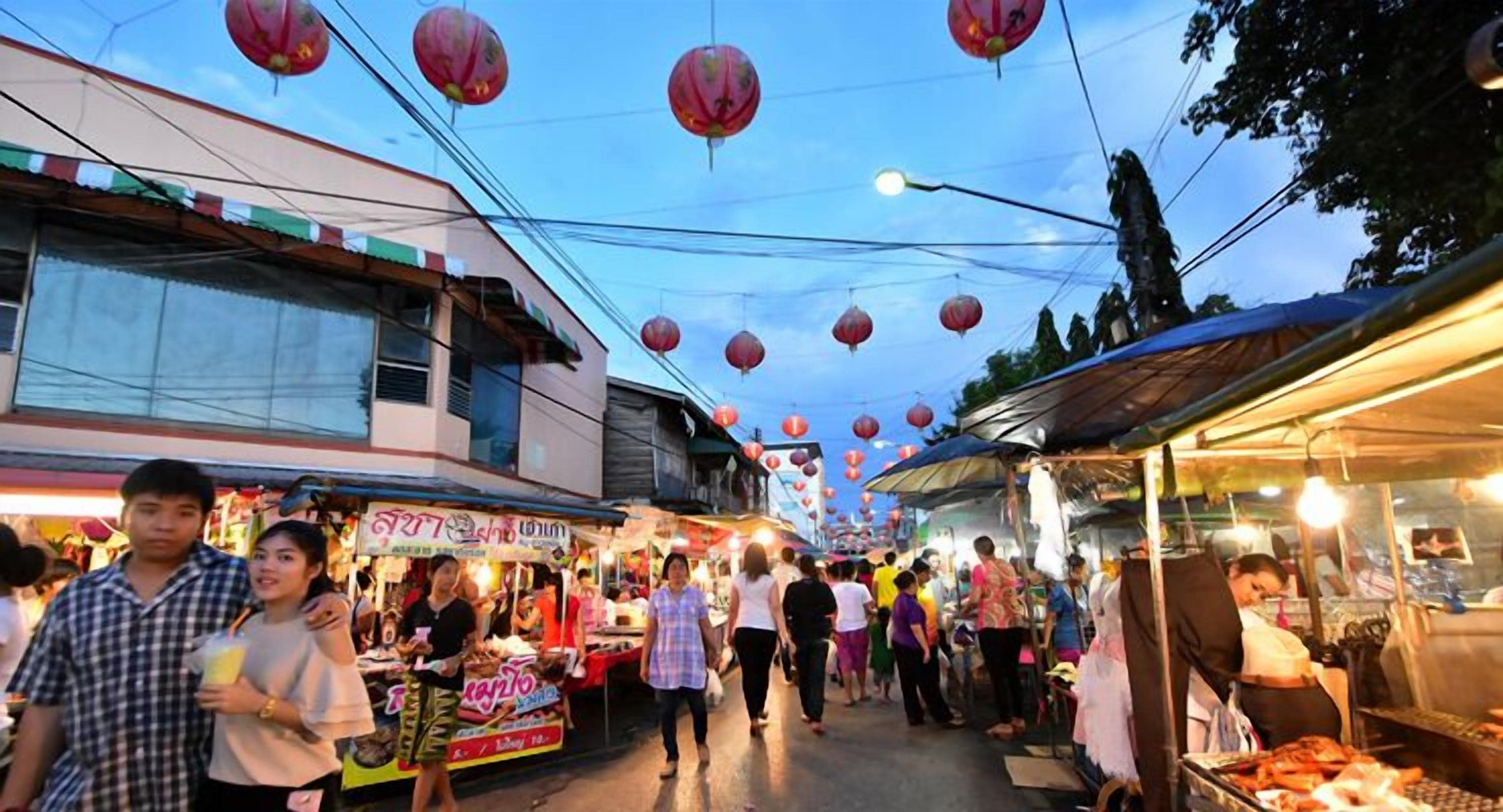 Un marché de rue animé, avec de nombreux étals et beaucoup de monde.
