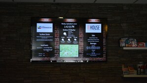 Eine digitale Anzeigetafel mit Informationen über lokale Veranstaltungen, Wettervorhersage und Speiseauswahl eines Restaurants.