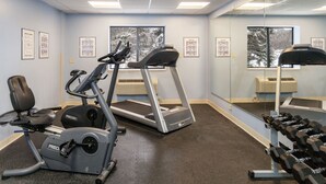 A gym with treadmills, an elliptical, and a bench press. - Days Inn by Wyndham Duluth Lakewalk (Duluth)