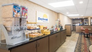 A breakfast area with a Kellogg's machine, a Daybreak sign, and a buffet with pastries and beverages. - Days Inn by Wyndham Duluth Lakewalk (Duluth)