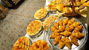 A buffet table with various baked goods and pastries. - Grand Hotel Tien Shan (Almaty)