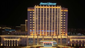 A hotel with a prominent 'Howard Johnson' sign, a central entrance, and a large staircase leading to the lobby.