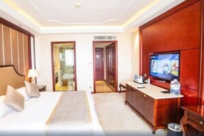 A hotel room with a bed, a TV, a desk, and a wardrobe. - Howard Johnson by Domando Plaza Wulanchabu (Ulaan Chab)