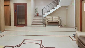 A spacious living area with a staircase, a sofa, and a ceiling fan. - La Sara Vista (Bengaluru)