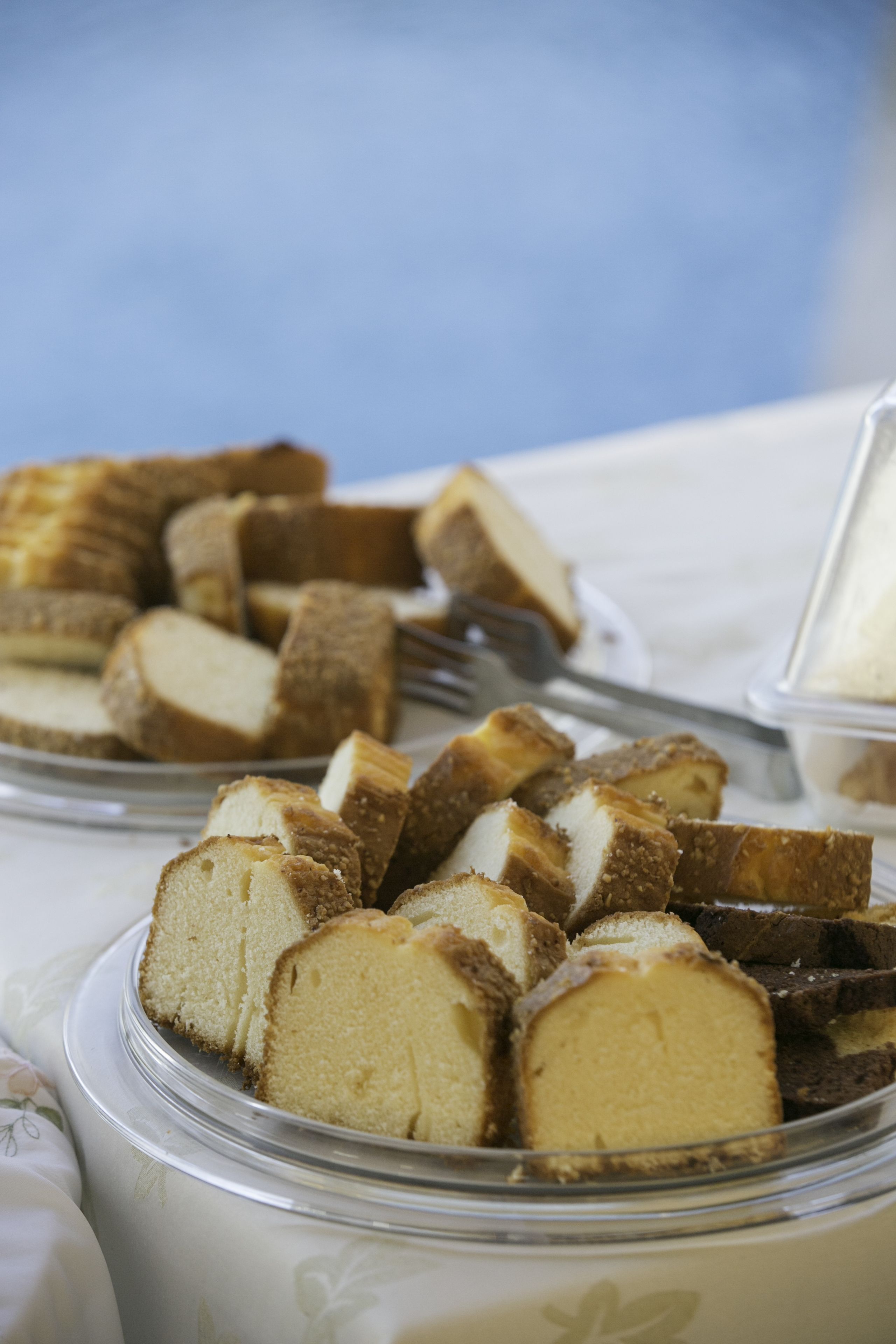 A dessert platter with slices of cake and a container of cream.